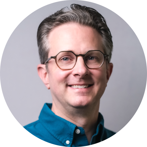 James Vest, bespectacled in a suit, smiling